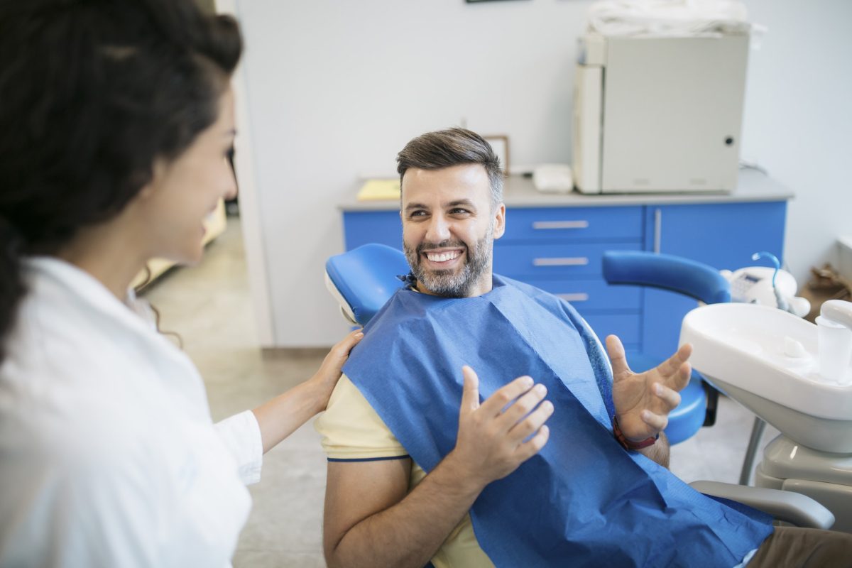Handsome young Caucasian man visiting a dentist's office